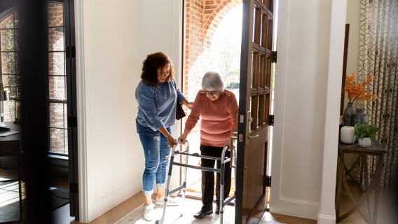 Mid-adult woman helps her senior adult friend, home healthcare, aging megatrend, senior care