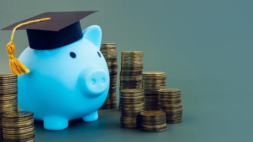Saving for college with a 529 plan. Piggy bank with graduation cap. Stacks of coins.