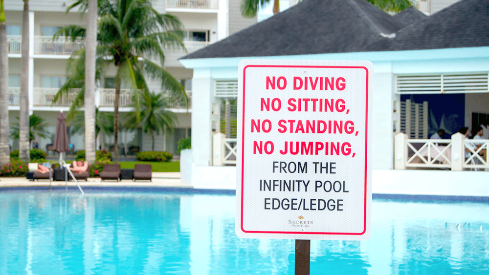 2 pool rules sign next to pool
