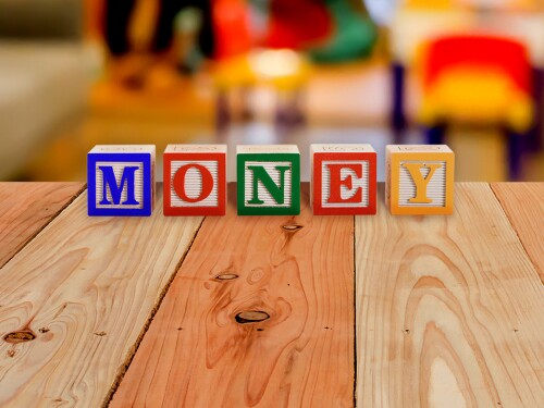 Kids play blocks that spell out 'money'