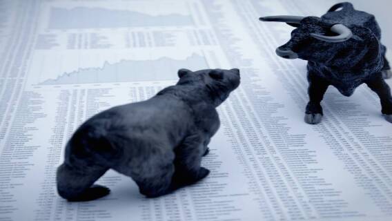 bull and bear facing off on a page of stock quotes signifying the battle for direction in a sideways market