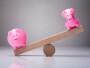 Unbalance Of Two Piggybanks On Wooden Seesaw representing outperformance of the biggest s&p stocks vs the rest