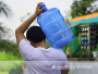 Person carrying a jug of water on their shoulders 