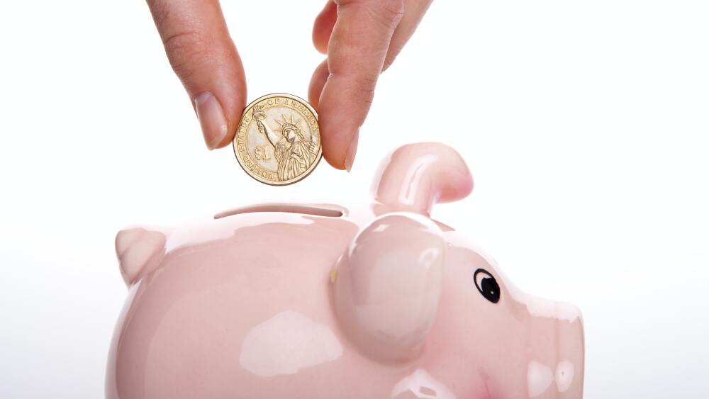 putting a coin in a piggy bank like making an ira contribution.jpg