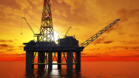 oil patch oil platform at sea with sunset