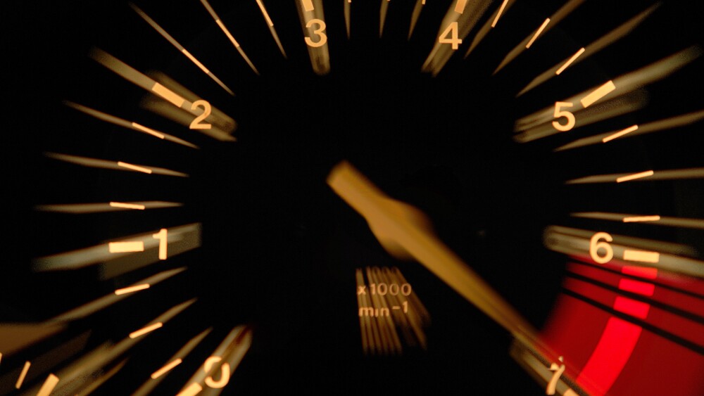 An up close image of a tachometer reaching a red line signifying the way energy drink stocks can rev up a portfolio