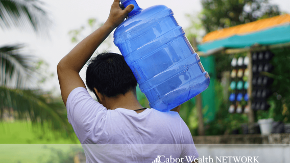 Person carrying a jug of water on their shoulders 