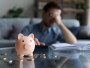 Piggy Bank in front of blurred image of a man that failed to avoid this common investing mistake