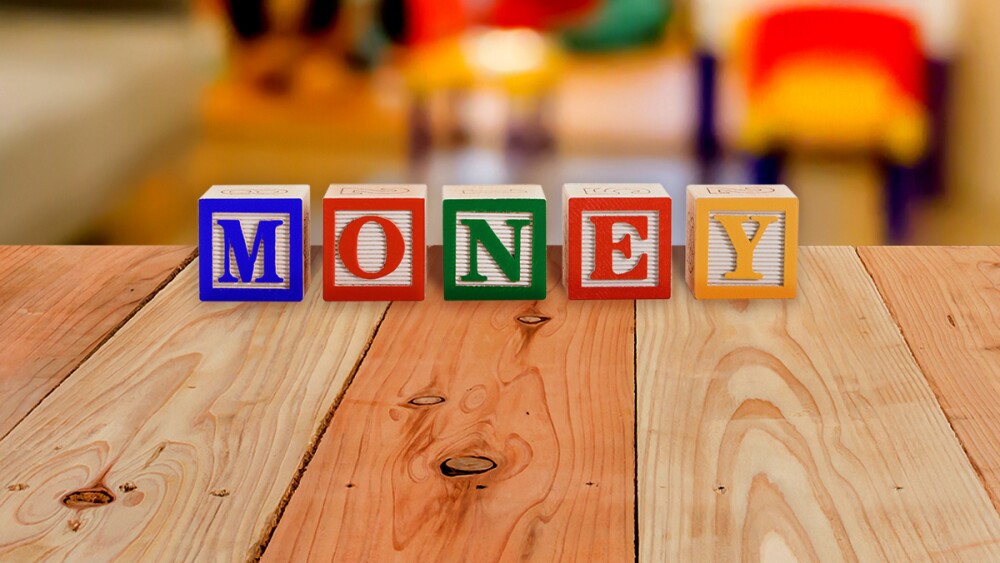Kids play blocks that spell out 'money'