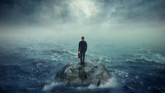 Uncertain man on a rock in choppy waters who would benefit from all-weather income stocks.